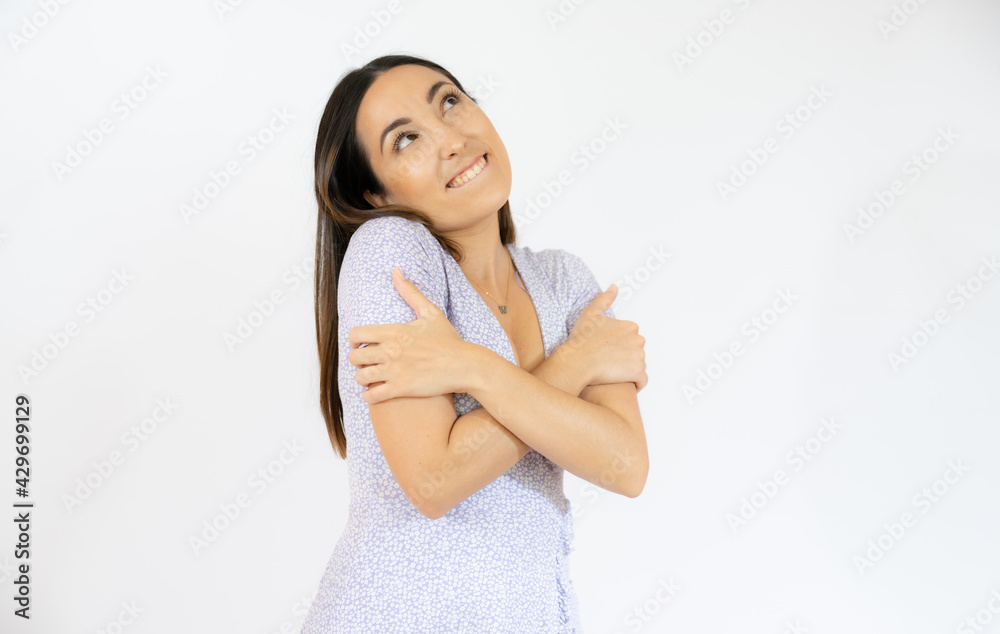 Young woman hugging herself isolated over white background. Young woman hugging herself isolated over white background.