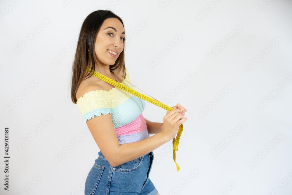 Closeup portrait of a happy young woman holding measuring tape Closeup portrait of a happy young woman holding measuring tape