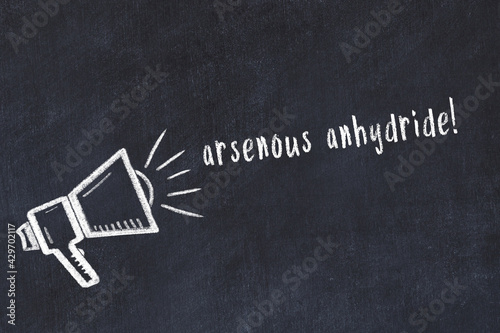 Chalk loudspeaker and inscription arsenous anhydride on black chalkboard photo