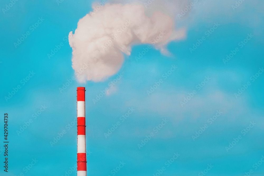Environmental pollution, environmental problem, smoke from the pipe of an industrial plant or thermal power plant against a blue sky