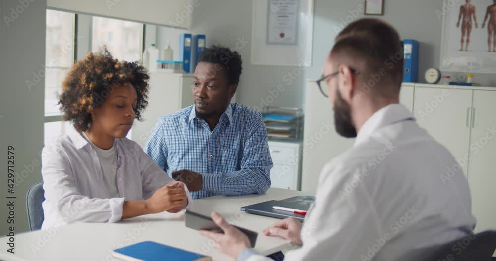 Upset afro-american couple visiting doctor at family planning clinic Upset afro-american couple visiting doctor at family planning clinic