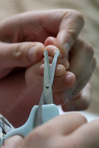 Mother cutting her baby s toenails with small scissors.