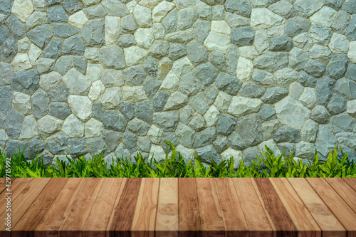 Empty wood table with stone wall texture background. For display or montage your products. © ParinPIX