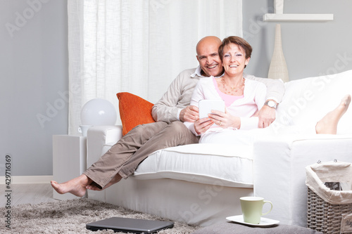 Happy joyful married middle-aged couple relaxing at home