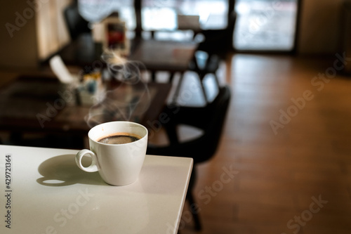 White coffee mug on the table inside the cafe