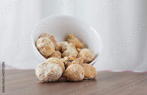 A handful of assorted chips in a white bowl on a wooden table - Stuffed Cavaca.