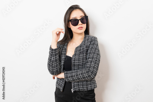 Beautiful Asian businesswoman with sunglasses on white background.