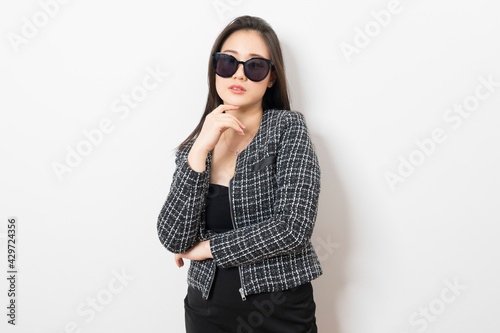Beautiful Asian businesswoman with sunglasses on white background.