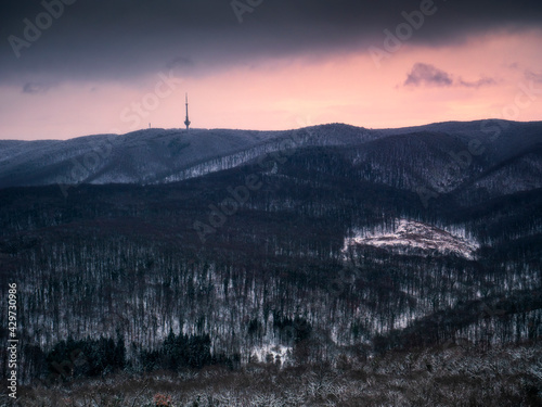 Dark mountain morning, winter lanscape with snow in the woods