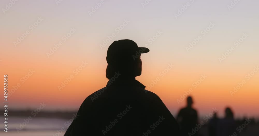 Silhouette of a man walking and looking off into the sunset at the beach. Shot on canon R5 4k 120fps. Silhouette of a man walking and looking off into the sunset at the beach. Shot on canon R5 4k 120fps.