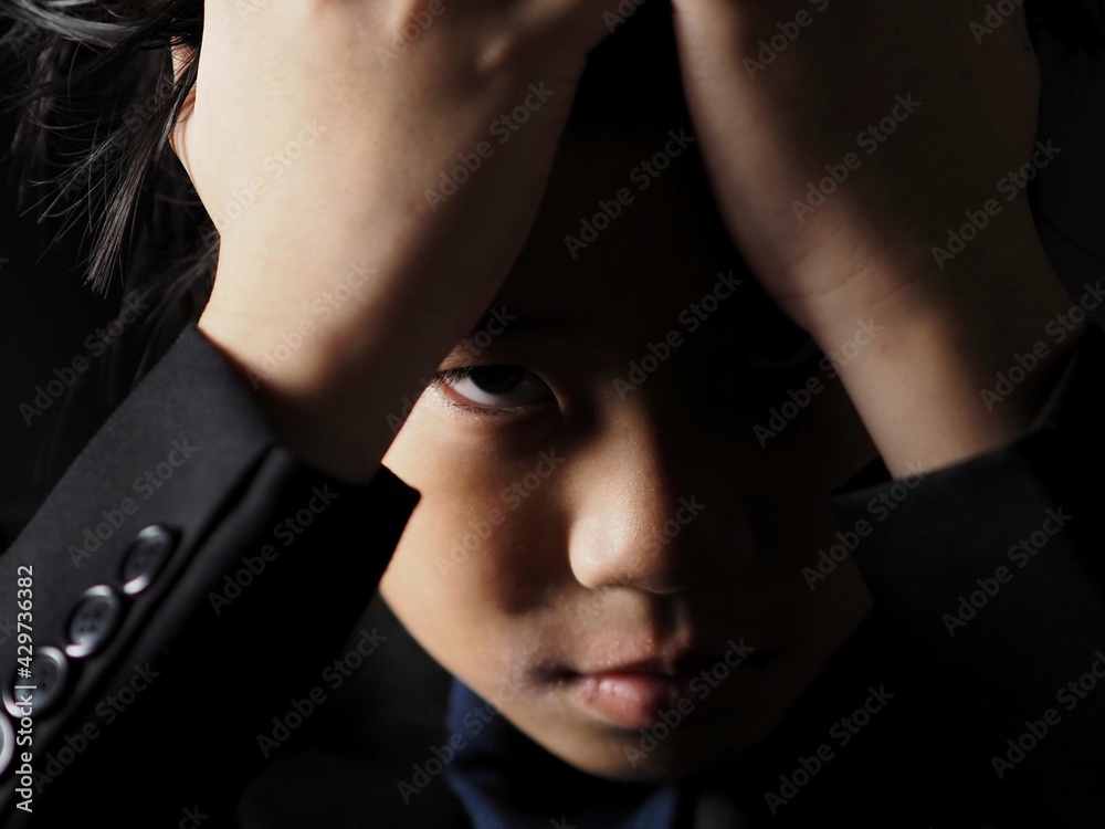 Portrait of asian boy dress with black suit in low key Portrait of asian boy dress with black suit in low key