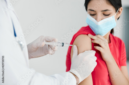 doctors in the hospital giving a shot to the patient's shoulder covid vaccination