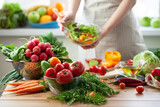 Beautiful young woman preparing delicious fresh vitamin salad. Concept of clean eating, healthy food, low calories meal, dieting, self caring lifestyle. Colorful vegetables, glass bowl. Close up