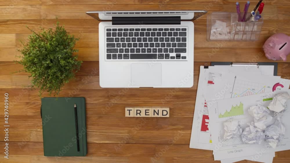 Word trend consists of wooden cubes letters on office table next to notebook. Term of trend made with hands of wooden cubes on table. Concept of fashion and tendency. Word trend consists of wooden cubes letters on office table next to notebook. Term of trend made with hands of wooden cubes on table. Concept of fashion and tendency.