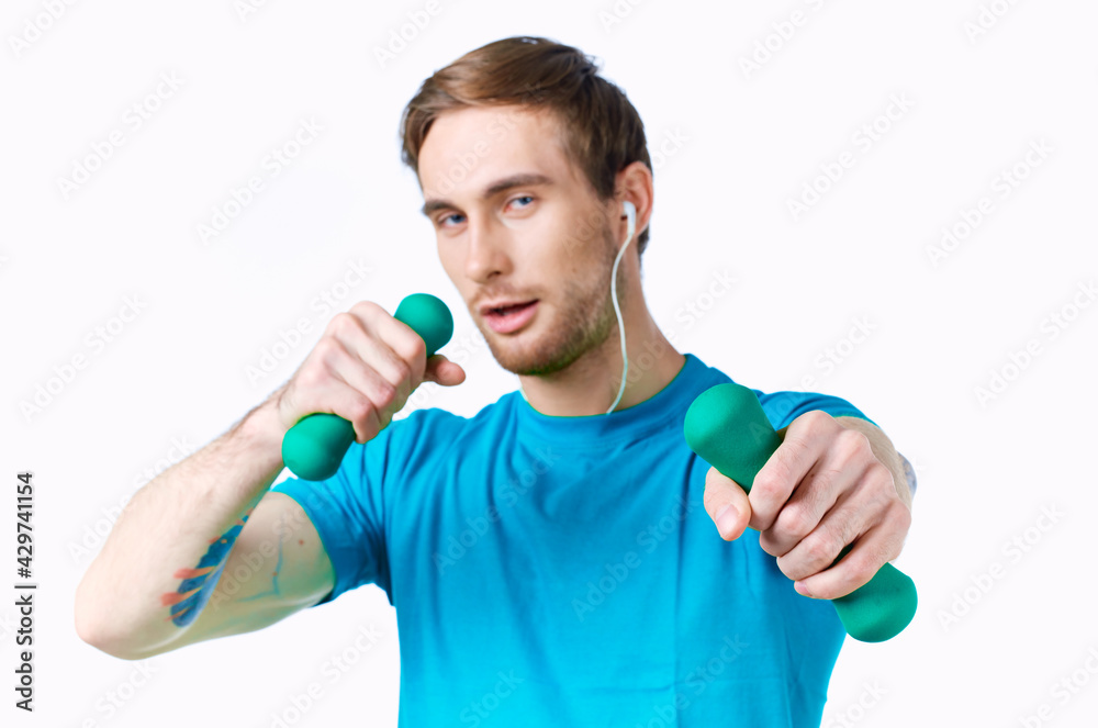 sports man with dumbbells in hands in headphones fitness exercise light background sports man with dumbbells in hands in headphones fitness exercise light background
