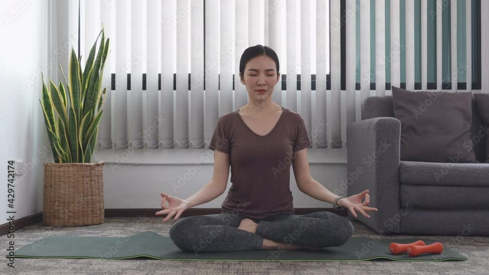 Woman doing yoga in the room, female happiness, Stretching the muscles of the body and practicing proper breathing, Exercise concept.