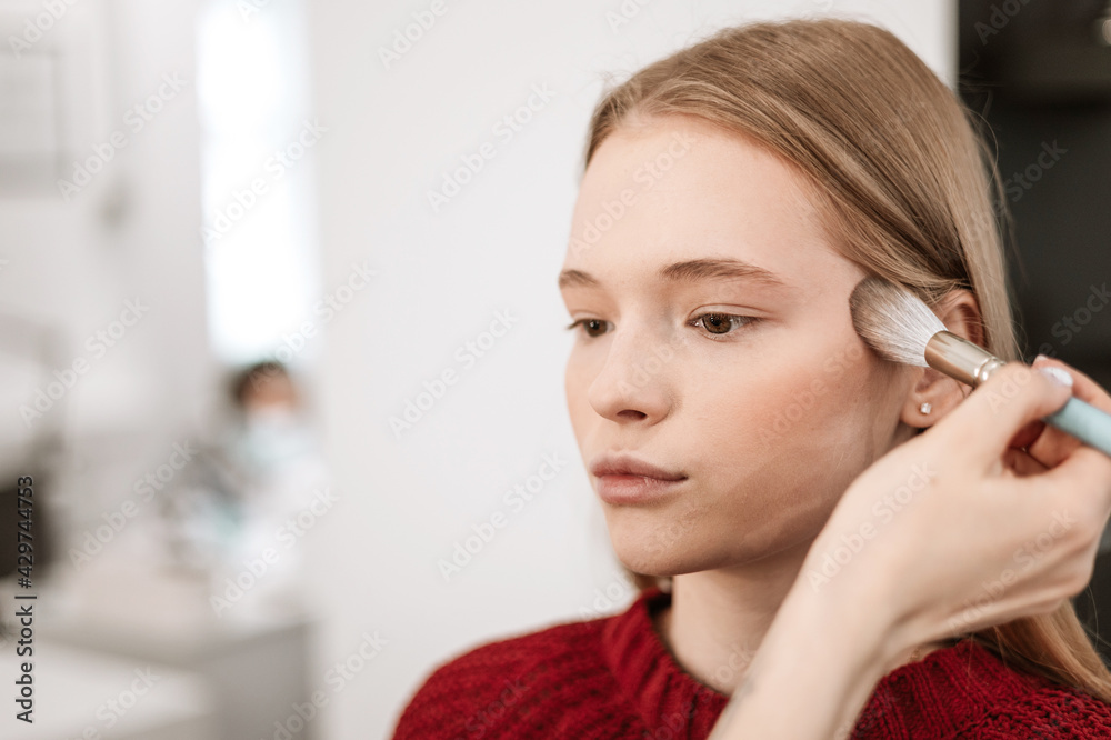 process of face makeup brush alignment of the face tone on a beautiful young woman model blonde process of face makeup brush alignment of the face tone on a beautiful young woman model blonde