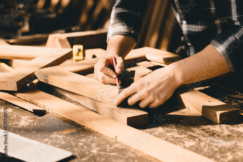 The carpenters high experienced wood worker making furniture. master of woodcraft male work with wooden handcraft piece with fine detail. photo