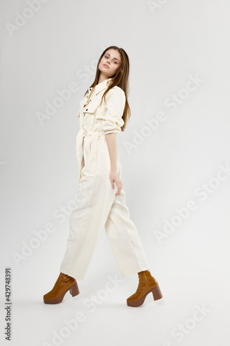 Charming Woman In Light Jumpsuit And Boots Fashion Style Side View