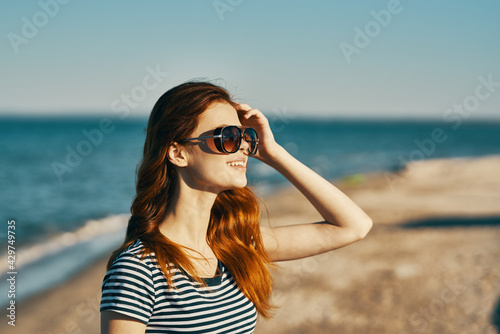woman with glasses and outdoors gesturing with hands above head cropped view