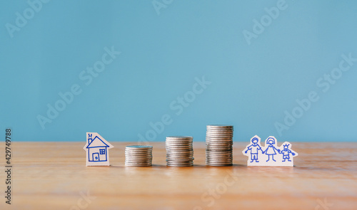 Stack of money coin on wood desk and blue background, Finance concept or Saving money for family, house. 