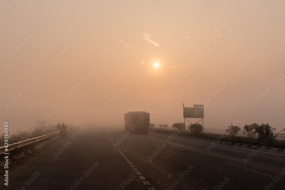 Indian Road Highways, Beautiful landscape of Indian roads during fog and sunrise in winter morning. Vehicles running on highways.