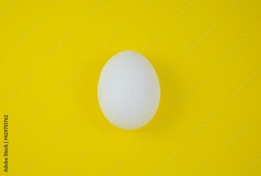 White egg on the yellow background. Copy space. Minimalism, original and creative photo. Beautiful wallpaper. Easter holidays. White egg on the yellow background. Copy space. Minimalism, original and creative photo. Beautiful wallpaper. Easter holidays.