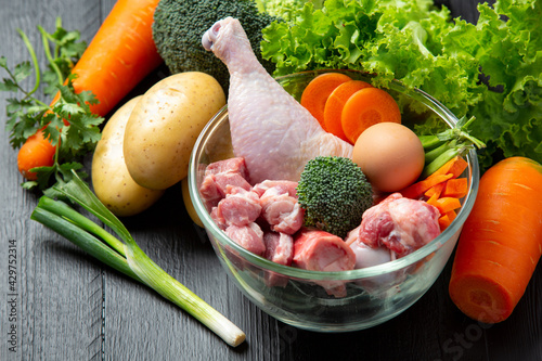Fotografie Healthy fresh pet food ingredients on dark background