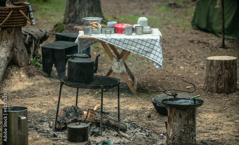Field kitchen in the forest, kettle on the fire. Hiking in the forest. Field kitchen in the forest, kettle on the fire. Hiking in the forest.