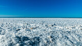 winter landscape by the sea, ice pieces of different sizes, sea horizon in the distance, blue sky