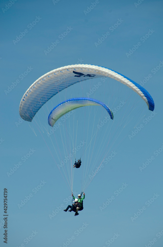Two paragliders flying in a blue sky Two paragliders flying in a blue sky