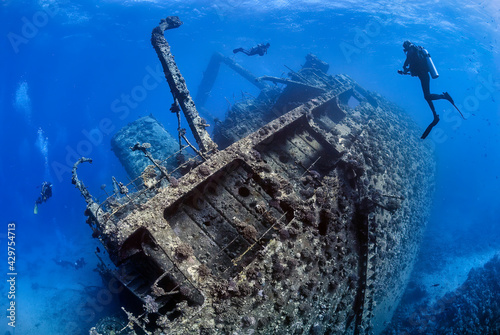 Fotografie Divers exploring the outside of a shipwreck