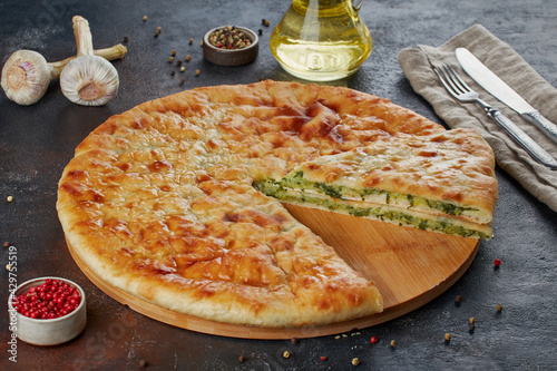 Traditional Caucasian dish - Ossetian pies with cheese, potatoes, herbs, cottage cheese, cherries, beef, mushrooms, dark background photo