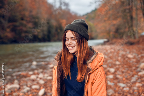 cheerful woman Tourist in a jacket Autumn forest river nature