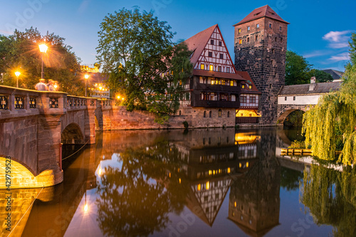 NUREMBERG, GERMANY, 27 JULY 2020: A colourful and picturesque view of the half-timbered old houses on the banks of the Pegnitz river in Nuremberg at night