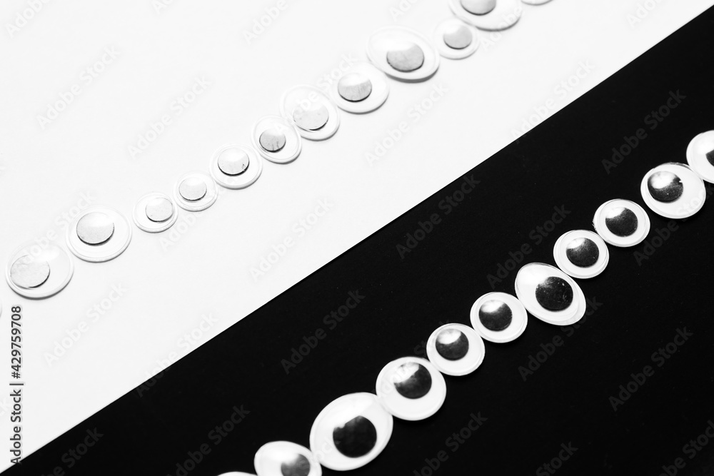 Toy eyes laid out on black and white hermetic background Stock Photo
