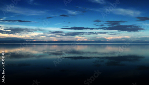 sunset on Adriatic sea, cloudy sky reflection on the water surface 