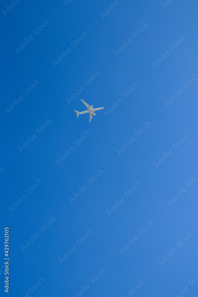 Airplane high in blue sky. Bright blue sky with a flight.