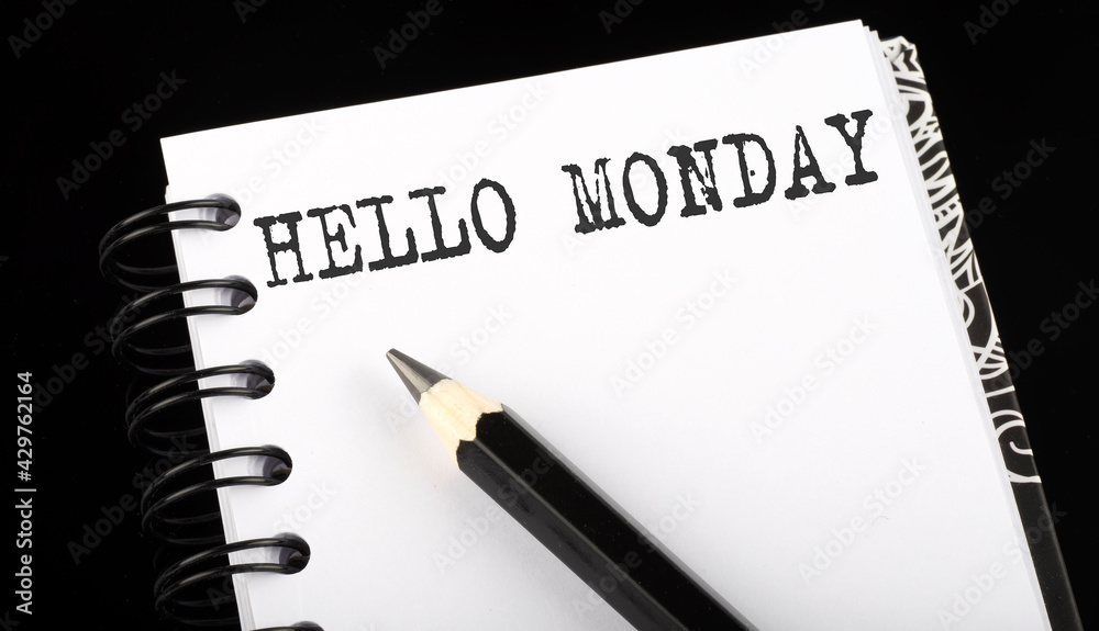 HELLO MONDAY written text in small notebook on a black background HELLO MONDAY written text in small notebook on a black background