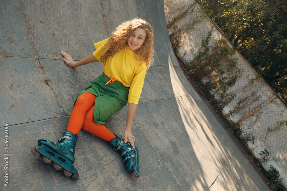 Young woman girl in green and yellow clothes going roller skate. Young woman girl in green and yellow clothes going roller skate.