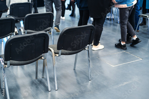 Chairs in the classroom against the background of the legs of the students. Low class attendance during a pandemic. Close-up