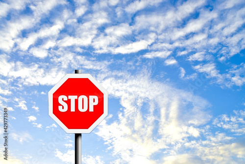 A traffic road stop sign on a blue sky background