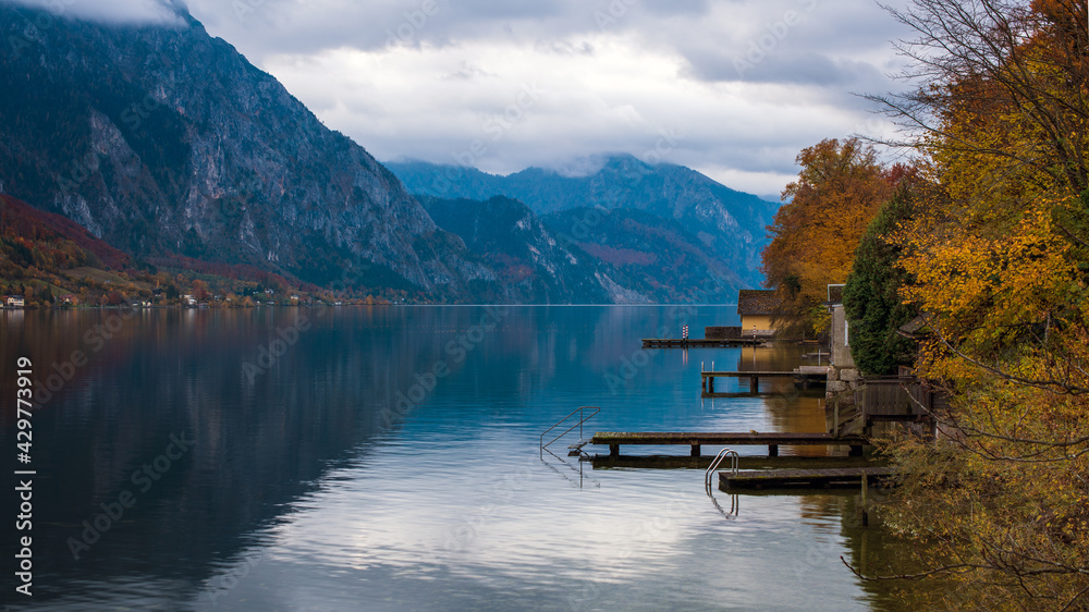 Morgendlicher Blick auf den Traunsee mit Bootsstegen und Bootshäusern, Oberösterreich, Österreich