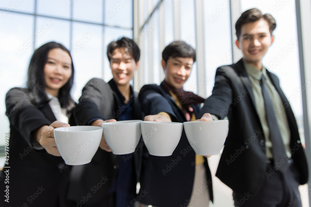Group of variety LGBTQ, man and woman, and transgender standing and push cups of coffee forward to the camera in the gesture of inviting to drink with a smile and happy faces Group of variety LGBTQ, man and woman, and transgender standing and push cups of coffee forward to the camera in the gesture of inviting to drink with a smile and happy faces
