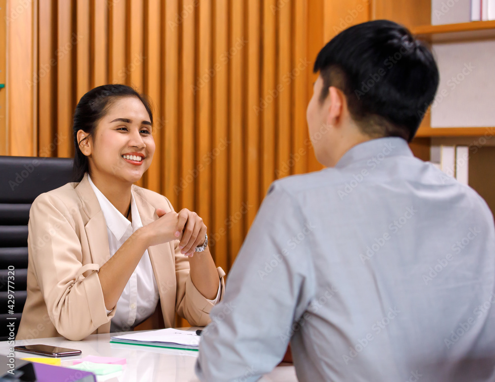 young attractive Asian businesswoman dressed smart casual smiling friendly and cheerful to the applicant during the interview in a company office. Confident and successful people concept young attractive Asian businesswoman dressed smart casual smiling friendly and cheerful to the applicant during the interview in a company office. Confident and successful people concept