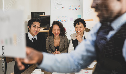 Selective focus on Attendee. African american men explaining the attendees snilling on a board, having graph papers at the conference room in the office. Concept meeting teamwork. photo