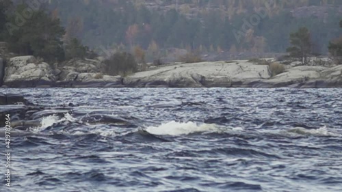 The powerful northern river flows among granite rocks surrounded by the Scandinavian taiga. Super slow motion 1000 fps gives a feeling of water density photo