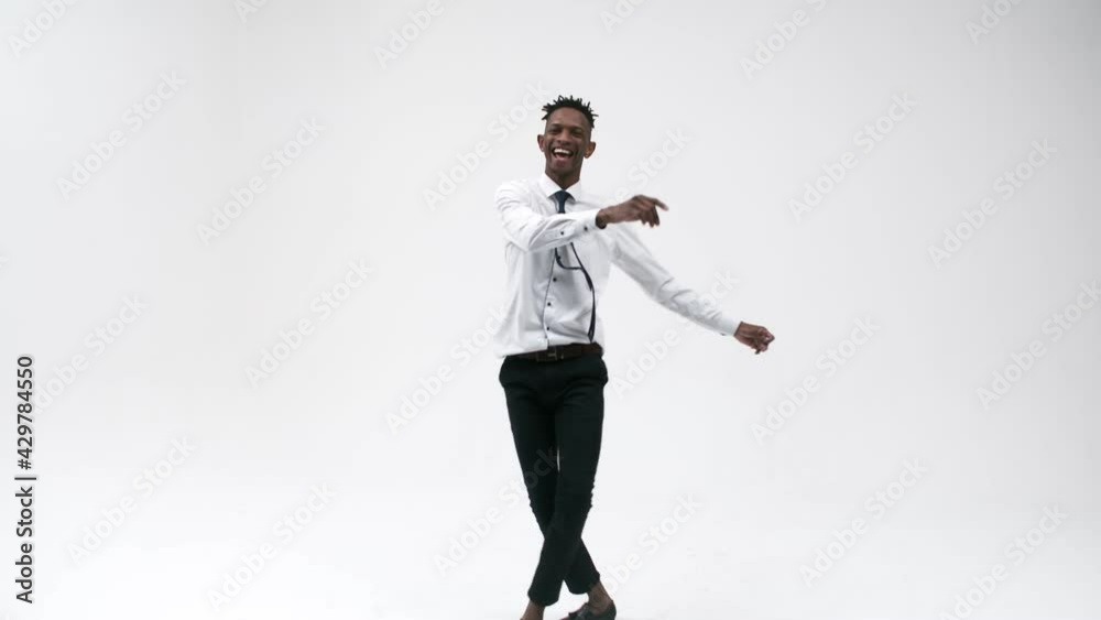 Black office man in a suit dances expressively and smiles in the studio against a white background. Black office worker dances vigorously. Concept of success and joy. Black office man in a suit dances expressively and smiles in the studio against a white background. Black office worker dances vigorously. Concept of success and joy.