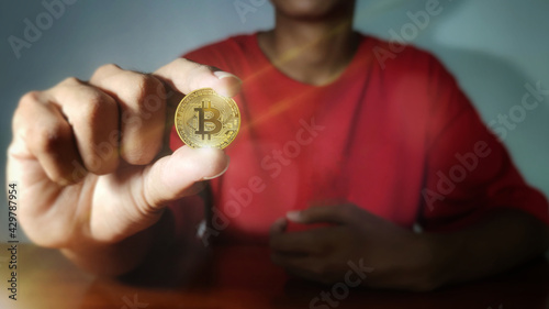 Bitcoin gold coin and defocused chart background. Business man with bitcoins. Virtual cryptocurrency concept.