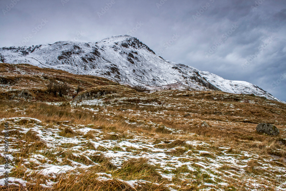  dramatic  photo of the wintry autumn weather and snow capped mountains in the Nant Ffrancon Pass and Ogwen valley in Snowdonia National Park in North Wales.